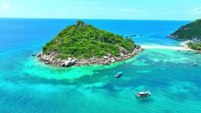Explore azure waters, wander secluded sandbars, and unwind amidst breathtaking landscapes on this sun-drenched island. Bird's eye view. Tropical sea background. Tao island, Thailand. 4K UHD.
