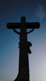 The cross on the Golgotha hill with beautiful clouds fast moving on the blue sky. Resurrection, new life, Easter video postcard. Vertical video.