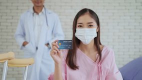 Young Asian woman patient wearing face mask holding credit card or insurance card. Payment medical treatment. Health care and insurance concept. Medical and health care concept - Powered by Shutterstock - Get 15% off with code: PIKWIZARD15