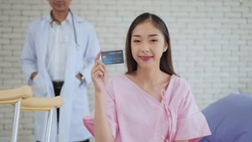 Beautiful young Asian woman patient holding credit card or insurance card, smiling to camera. Payment medical treatment. Health care and insurance concept. Medical and health care concept - Powered by Shutterstock - Get 15% off with code: PIKWIZARD15