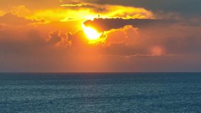 From the aerial perspective of a drone, witness the majesty of the sun setting over the boundless expanse of the sea, a breathtaking spectacle of nature. Aerial view. Ocean loop video background. 4K.
