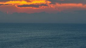 A drone's eye reveals the majesty of the sun setting over the vast expanse of the ocean, a breathtaking panorama. Drone aerial view. High-quality video. Nature loop video background. 4K.
