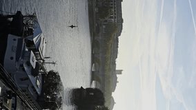Vertical video of morning near the River Seine with ship and arch bridge
