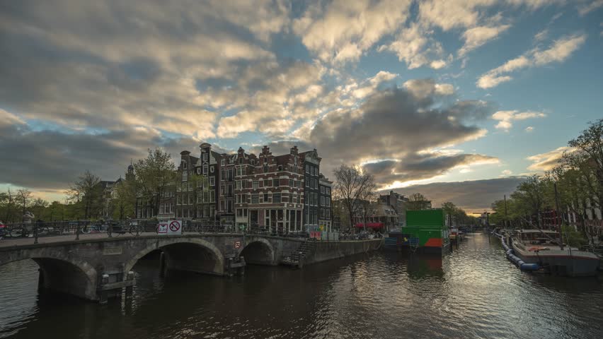 Amsterdam Netherlands time lapse day to night sunset city skyline at canal waterfront