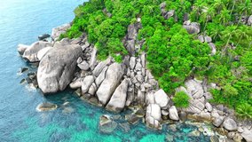 Discover a picturesque blend of rocky shores and verdant forests, accentuated by swaying coconut trees, all kissed by the mesmerizing hue of turquoise waters. Stock footage. Tao island, Thailand. 4K.
