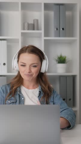Through the webcam on her laptop, the woman in headphones makes productive video calls. It communicates with colleagues, students or clients, providing effective communication at remote work and study