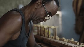 African American carpenter working on creation of wooden musical instrument, repairing old piano keyboard - Powered by Shutterstock - Get 15% off with code: PIKWIZARD15