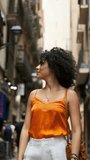 Tourist woman with curly hair enjoying a walk through the streets of Barcelona.