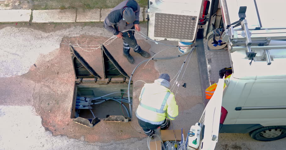 telecommunication technician proceeds with the cabling of fibre optic cables. In particular, individual fibre optic cables are pulled out of the protective sheathing
