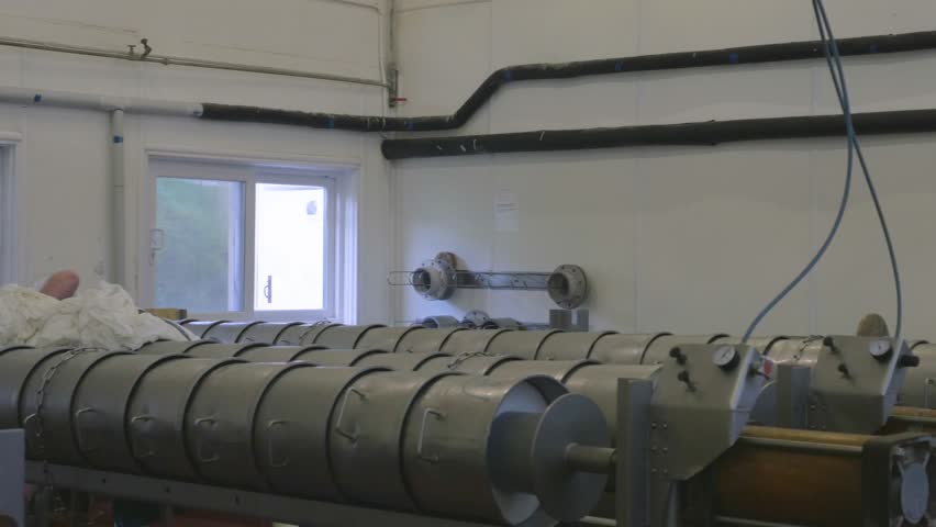 Factory employee carrying out work to cheese vats