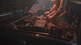 Two mechanics at service check car after receiving diagnostic results. Beautiful female specialist wipes engine with rag. Professional repairman using tools to troubleshoot. - Powered by Shutterstock - Get 15% off with code: PIKWIZARD15