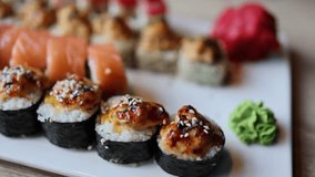 The video an assortment of Japanese sushi rolls, showcasing the exquisite combination of fresh fish and rice. The vibrant and meticulously crafted rolls reflect the artistry of Japanese cuisine.