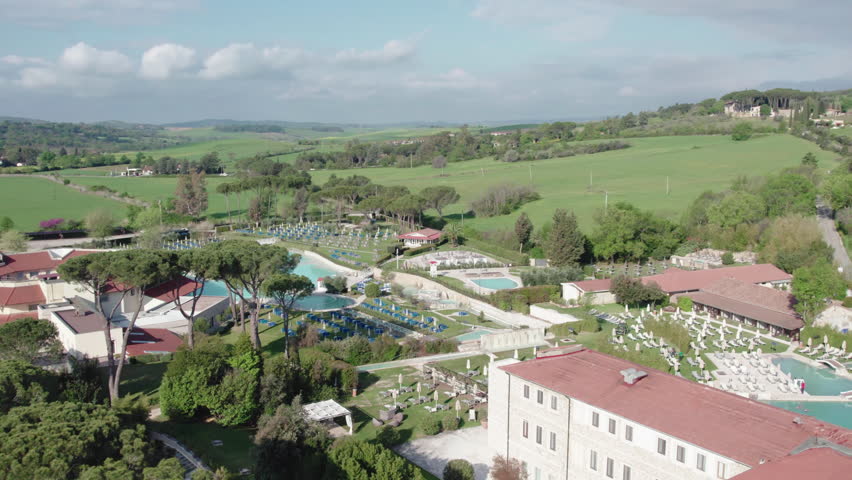 Tuscany hotel resort with thermal springs of turquoise colour from aerial view shot, large modern hotel complex with thermal pools on territory, Tuscany thermal springs with healing properties and