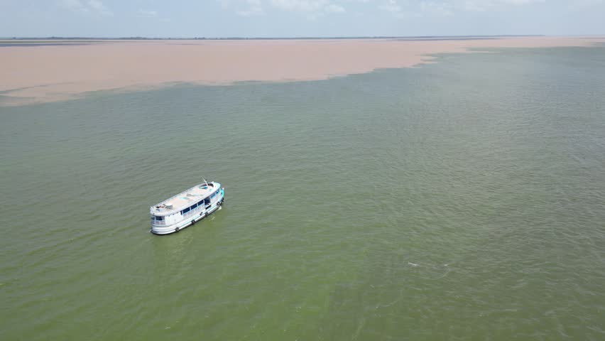 Aerial drone view of a passerger boat near the confluence of the Tapajos and Amazon rivers.
