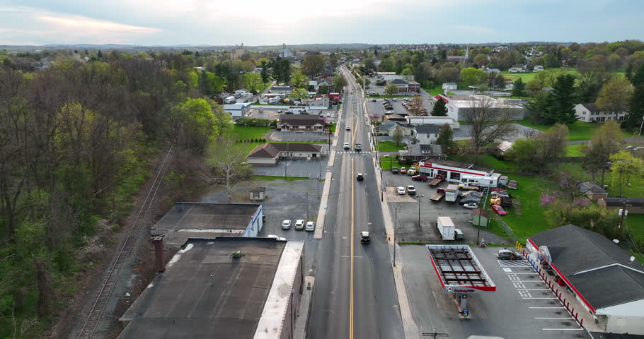 Street through small town in America. Spring season with rural poor community. Reverse dolly aerial.