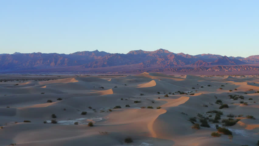 Sunset landscape for travel destination. Death Valley, California. Dunes and mountains in the background. Aerial