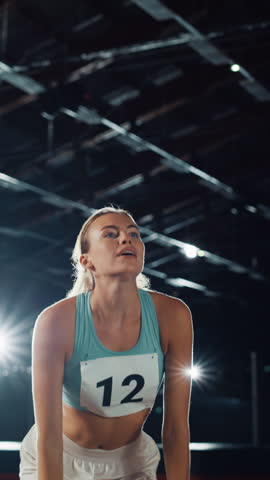 Vertical Video. Portrait of Professional Female Athlete Happily Jumping Celebrating New Record on a Sport Championship. Determined Successful Sportswoman Raising Arms after Winning Gold Medal Royalty-Free Stock Footage #3449988521