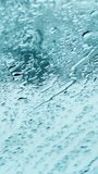 Close-up of water droplets from melting snowflakes on the glass. Snowflakes fall on the windshield of a car and melt during a snowfall. Vertical videos, shorts.