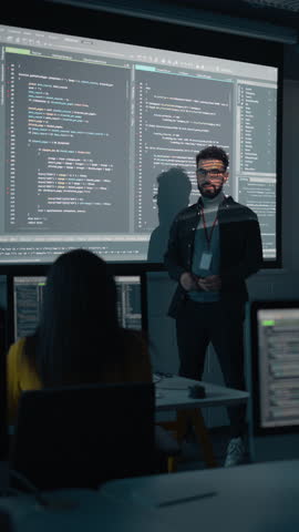 Vertical Screen: Teacher Giving Computer Science Lecture to Diverse Multiethnic Group of Students in Dark College Room. Projecting Slideshow with Programming Code. Explaining Information Technology. Royalty-Free Stock Footage #3450032103