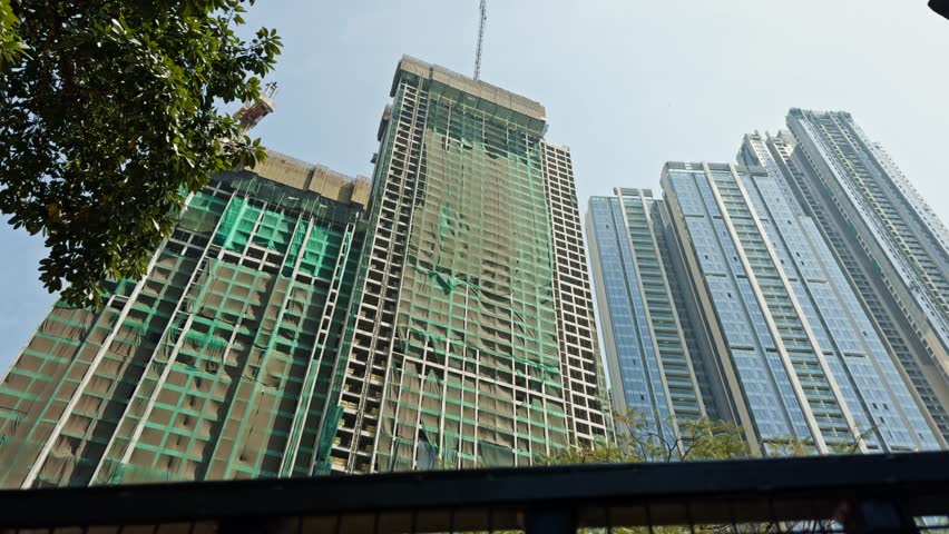 Modern skyscrapers towering amidst urban greenery, Under a clear sky, Under constructed high-rise building, Office business park tower, on clear blue sky, Asia, India