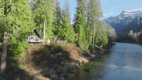Forest cabin in magical Washington at forest river with mountain view at golden sunset. Small rustic countryside house hides between evergreen trees in mountain forest at blue river.Log cabin in woods - Powered by Shutterstock - Get 15% off with code: PIKWIZARD15