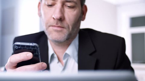 Businessman using his smart phone - tracking shot