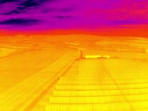Aerial infrared thermal view of solar power plant on large photovoltaic farm, in purple and yellow hues