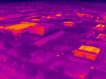 Aerial infrared thermal view of industrial zone with factories and warehouses, in purple and yellow hues