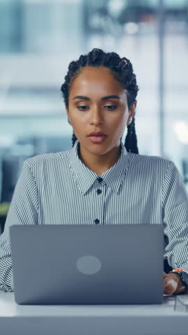 Vertial Video. Young Black Woman Office Worker Uses Laptop, Feels Sudden Burst of Pain, Headache, Migraine. Overworked Accountant Feeling Project Pressure, Stress, Massages Her Head, Temples Royalty-Free Stock Footage #3450089103