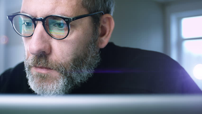 Portrait of a businessman with glasses working concentrated with his computer - slow tracking shot