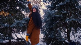 Playful woman throwing snowballs in winter. Snow falling off gloves in slow motion. Fun outdoor activity concept. HD video footage available.
