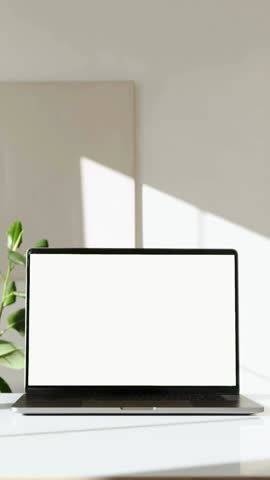 Workplace with laptop computer on desk with blank empty green mockup screen for advertising standing in modern contemporary office. Home interior or office background Royalty-Free Stock Footage #3450172219