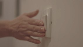 Close up of woman left hand turning on light switch in the apartment  - Powered by Shutterstock - Get 15% off with code: PIKWIZARD15