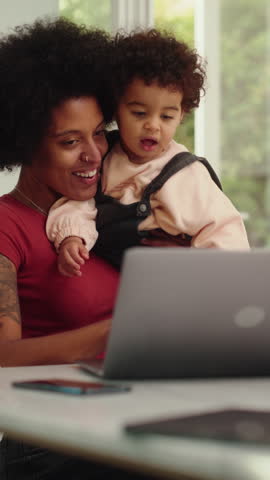 Vertical Screen: Modern Young Mom Holding Adorable Baby Son, Using Laptop Computer in Living Room in Apartment. Mother is Working from Home, Online Shopping, Watching Social Media or Writing Emails. Royalty-Free Stock Footage #3450176177