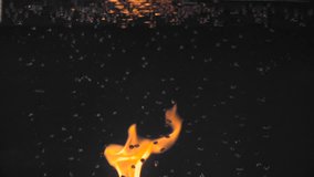 Bright flame of fire through the aquarium which are rising up the air bubbles. Slow motion.