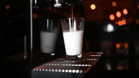 Coffee machine making latte macchiato in transparent glass