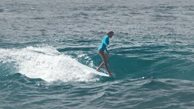 Woman surfer rides the wave in the Maldives and does hang five surfing trick on the longboard - Powered by Shutterstock - Get 15% off with code: PIKWIZARD15