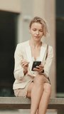 VERTICAL VIDEO, Businesswoman with blond hair talking on cellphone