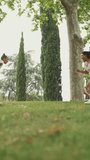 VERTICAL VIDEO: Three girls friends pre-teenage walk in the park playing tag . Three girls friends teenage play got you last game