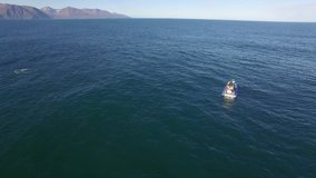 HUSAVÍK, ICELAND – SEPTEMBER 2016 : Aerial shot over whale watching boat on a beautiful day with ocean in view