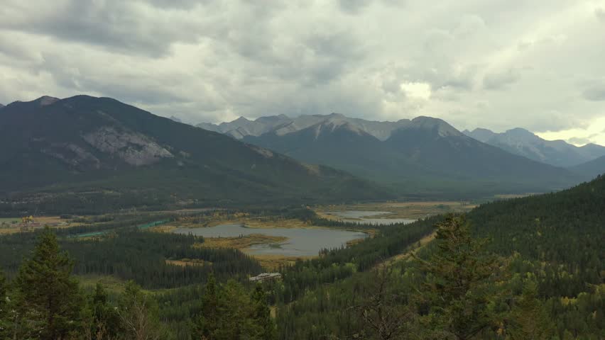 Nice aerial view of the Bow River and Vermilion Lakes on a cloudy day near Banff, Alberta. Royalty-Free Stock Footage #3450371149