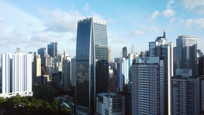 Aerial view circling in front of the Makati city skyline, in sunny Manila, Philippines