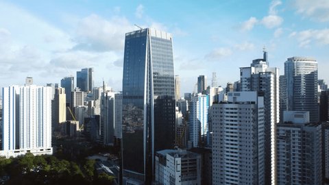 Aerial view circling in front of the Makati city skyline, in sunny Manila, Philippines: stockvideo
