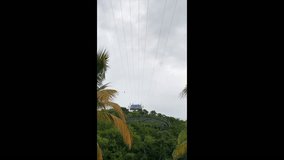 Adrenaline Beach at Labadee, Haiti. Dragon's Fire and Dragon's Breath zipline over beach and palm trees. Labadee is a private resort leased by Royal Caribbean Cruises. Vertical video.