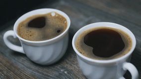 Two small cups of hot freshly brewed black coffee. Close up.