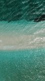Top view of ocean waves over the sandbar of White Island in Camiguin Island. Philippines. Summer and travel concept. Vertical video.