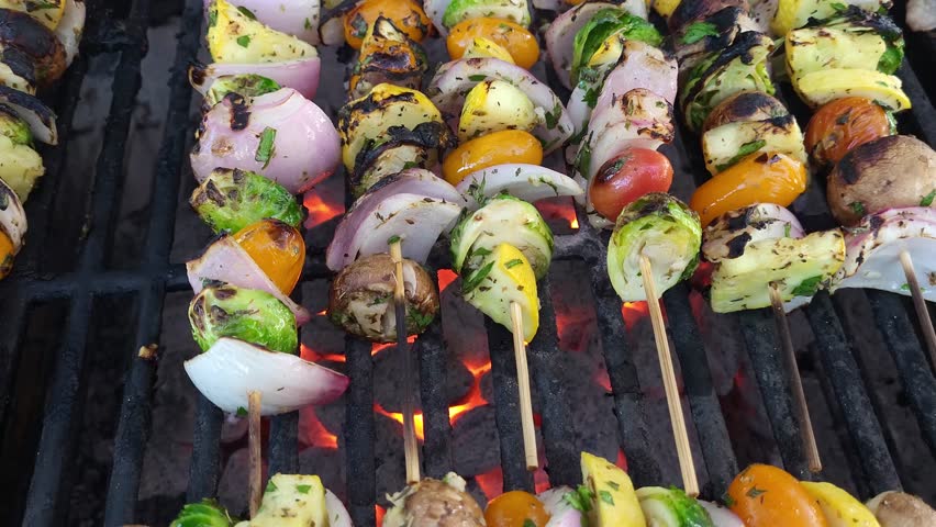 Grilling veggie kabobs on a charcoal grill, close up view