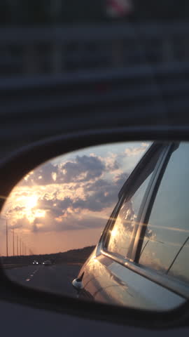 Reflection Of The Sunset In The Rearview Mirror Of The Car. Vertical. Royalty-Free Stock Footage #3450584949