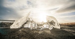 ICELAND – SEPTEMBER 2016 : Timelapse of ice rock on Diamond Beach with sun and clouds moving in background on a beautiful day