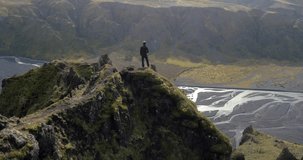 ICELAND – SEPTEMBER 2016 : Aerial shot of man standing on cliff over amazing landscape in Thorsmörk National Park on a beautiful day
